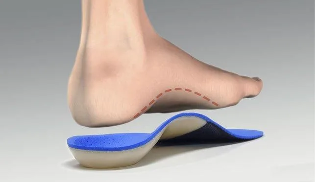 A custom insole under a foot, showing how it supports the arch